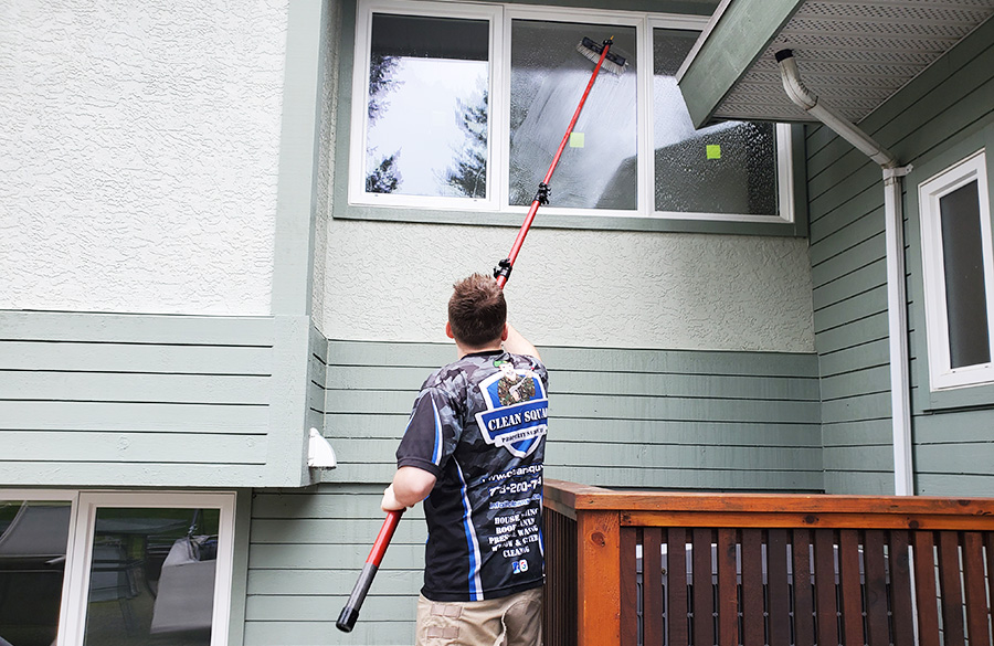 a clean squad employee washes windows